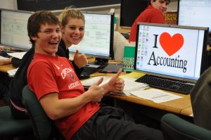 Young college students working on a computer that says "I love accounting"