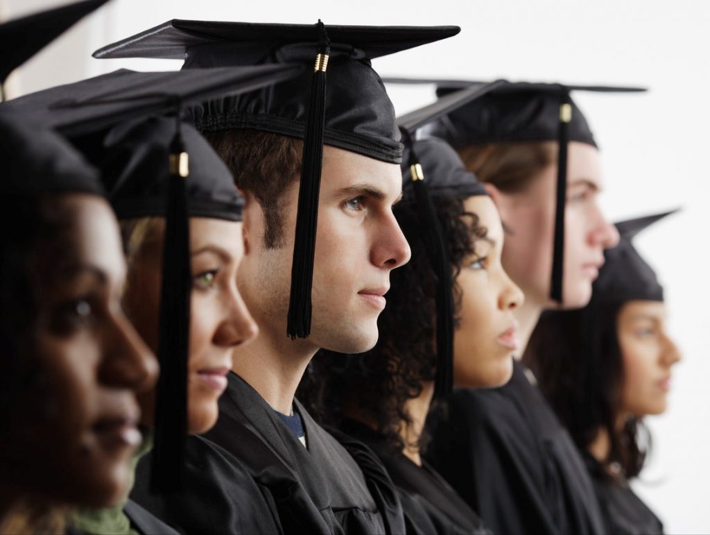 Group of college students wearing caps and gowns