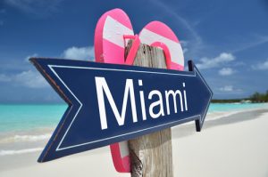 Sign pointing to Miami Beach with sandals on it