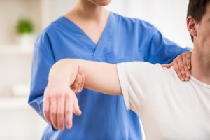 Physical therapist treating a patient's arm