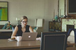 Young woman with glasses works on her laptop