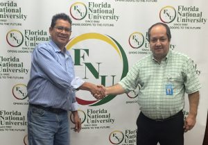 Dental director Dr. Restrepo poses with Alumnus in front of FNU Banner