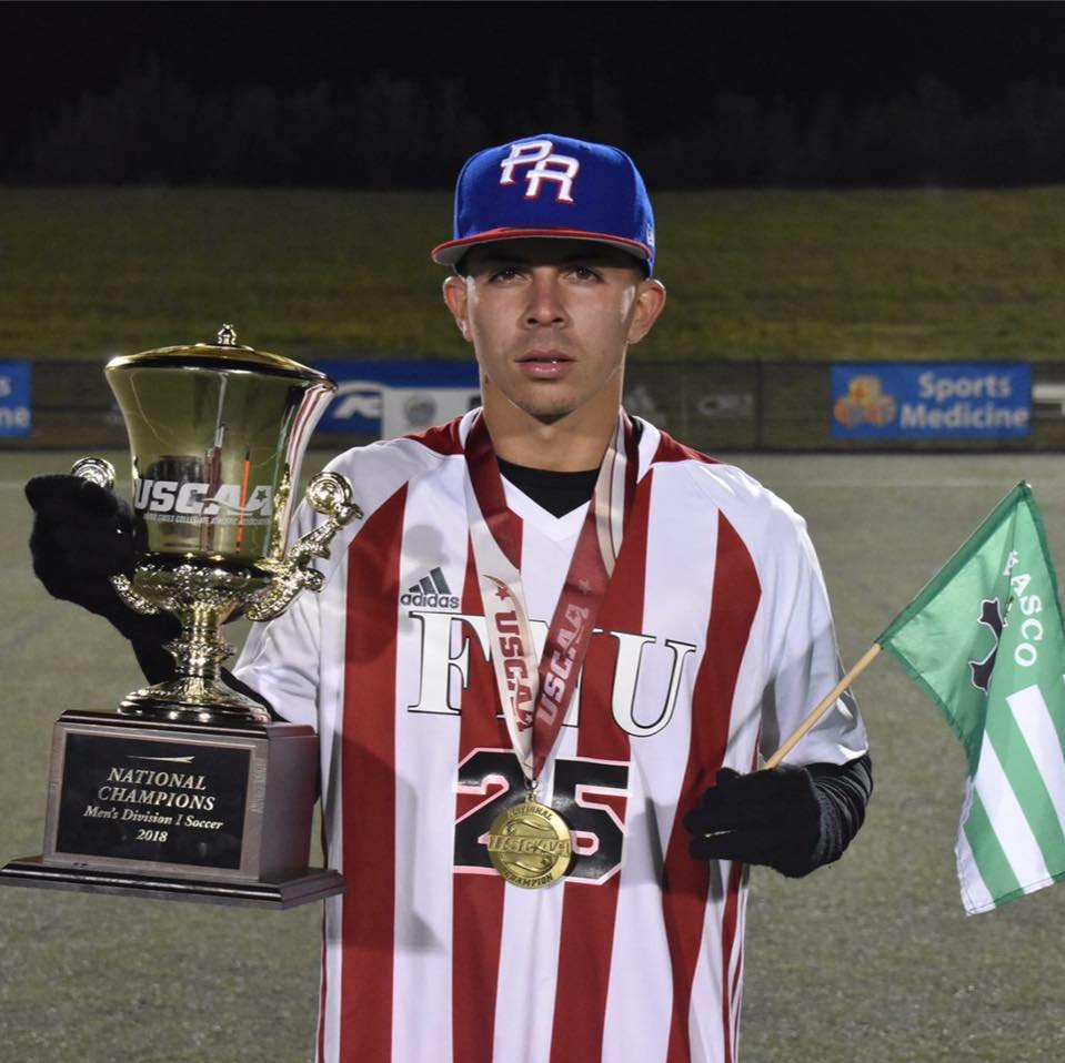 George Perez FNU Soccer Player holding a National Champions trophy