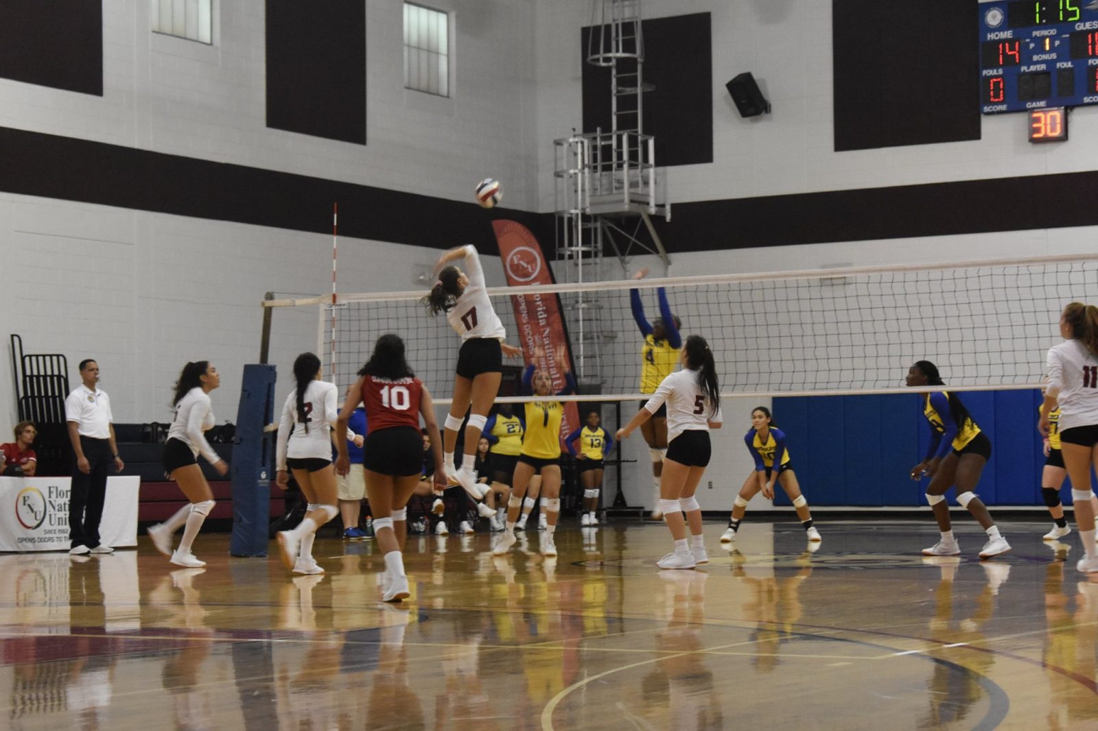FNU Volleyball player attacking the ball and opponent players trying to block the ball