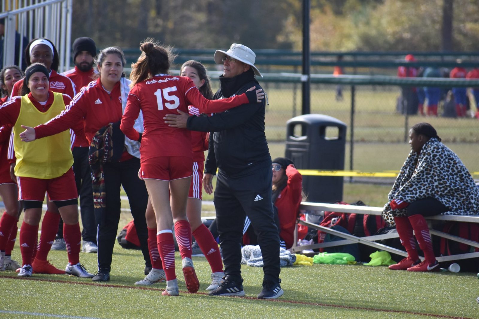 Women's soccer player Mickaela celebrating a goal with coach Giovanni