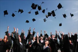 Students throwing hats after graduating from associate's degree programs.