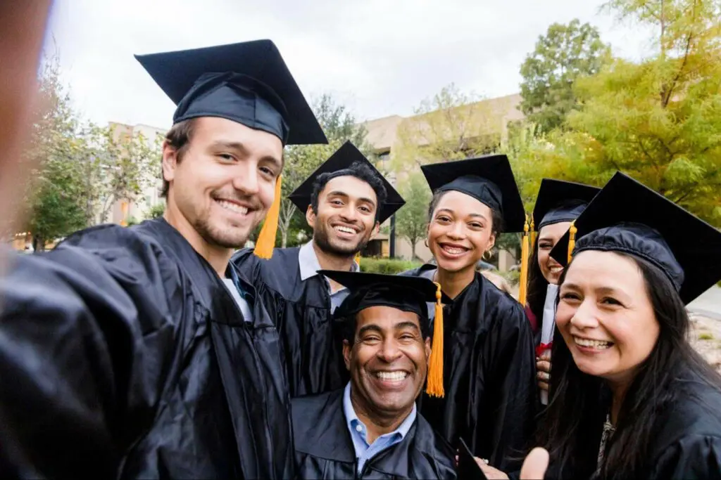 Group of diverse college graduates smiling in caps and gowns, celebrating their career development