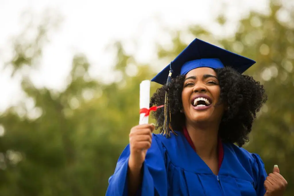 Happy graduate woman in blue cap and gown holding diploma, symbolizing career education advancement