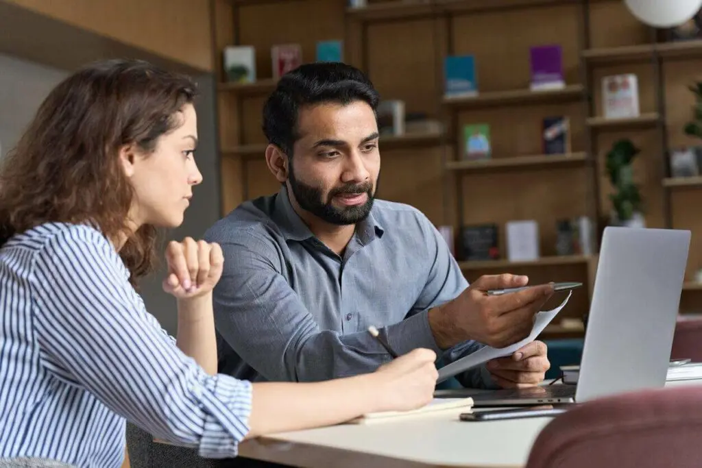 Academic advisor and college student reviewing student career advice and career guidance and development resources on a computer