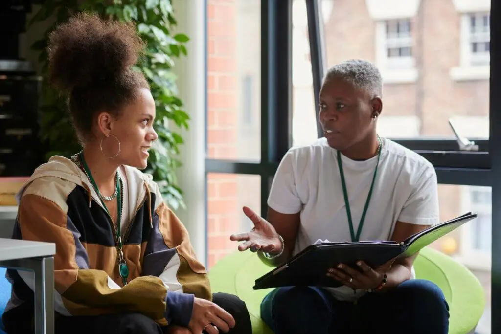 Academic advisor giving career advice to a smiling student during a meeting