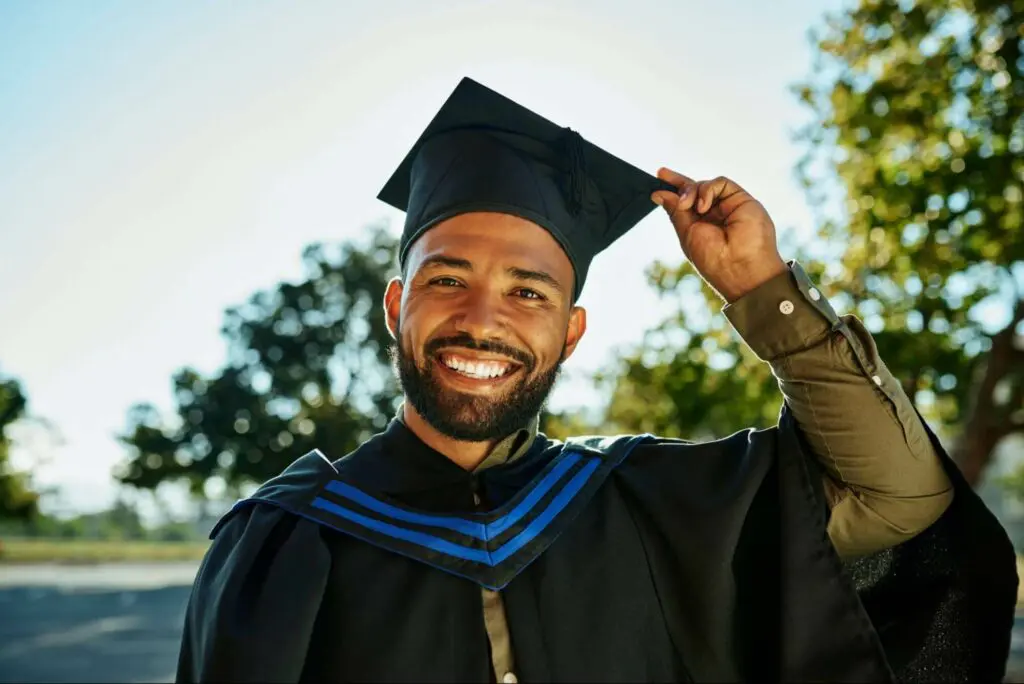 A male graduate student at graduation after completing a capstone project