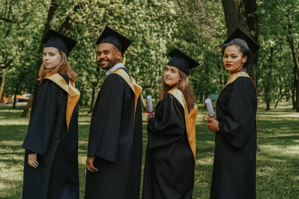 Diverse group of college graduates celebrating outdoors, representing success through accelerated degree programs for working adults.