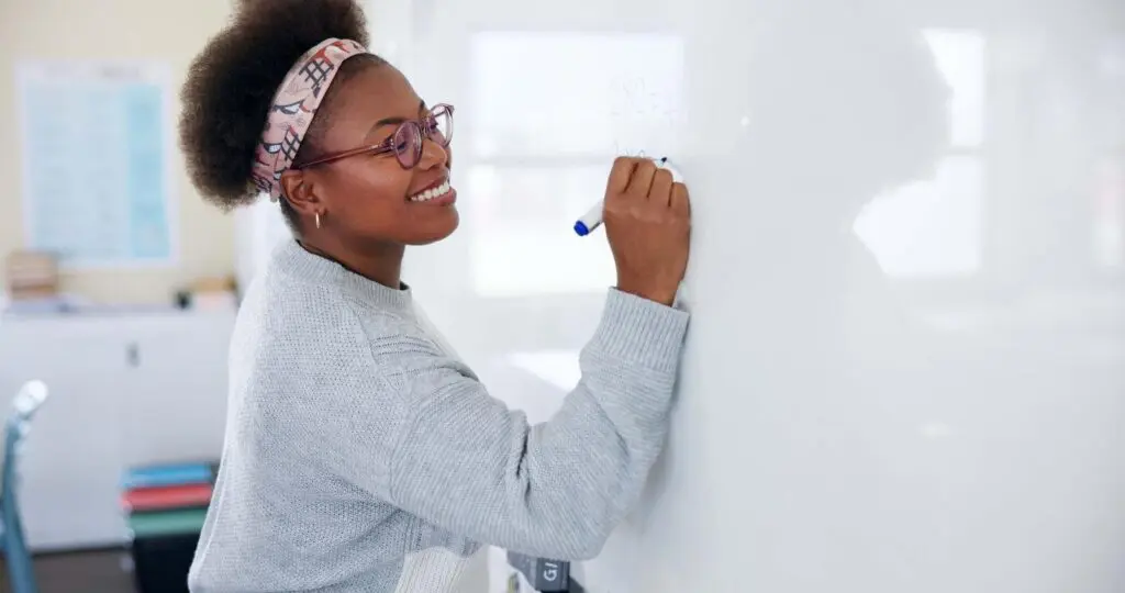 Teacher writing on whiteboard for master’s degree in education