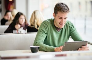 Man using tablet in coffee shop