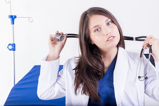 young girl in medical coat holding stethoscope 