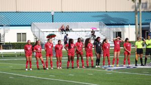 FNU women's soccer team lined up on field before a match versus St. Thomas.