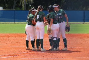 FNU softball players in a huddle.